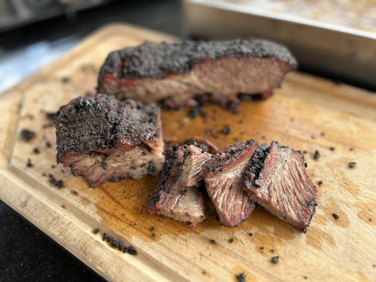 Saftiges Smoked Beef Brisket mit kräftiger Kruste, aufgeschnitten und serviert auf einem Holzbrett – BBQ-Genuss pur.