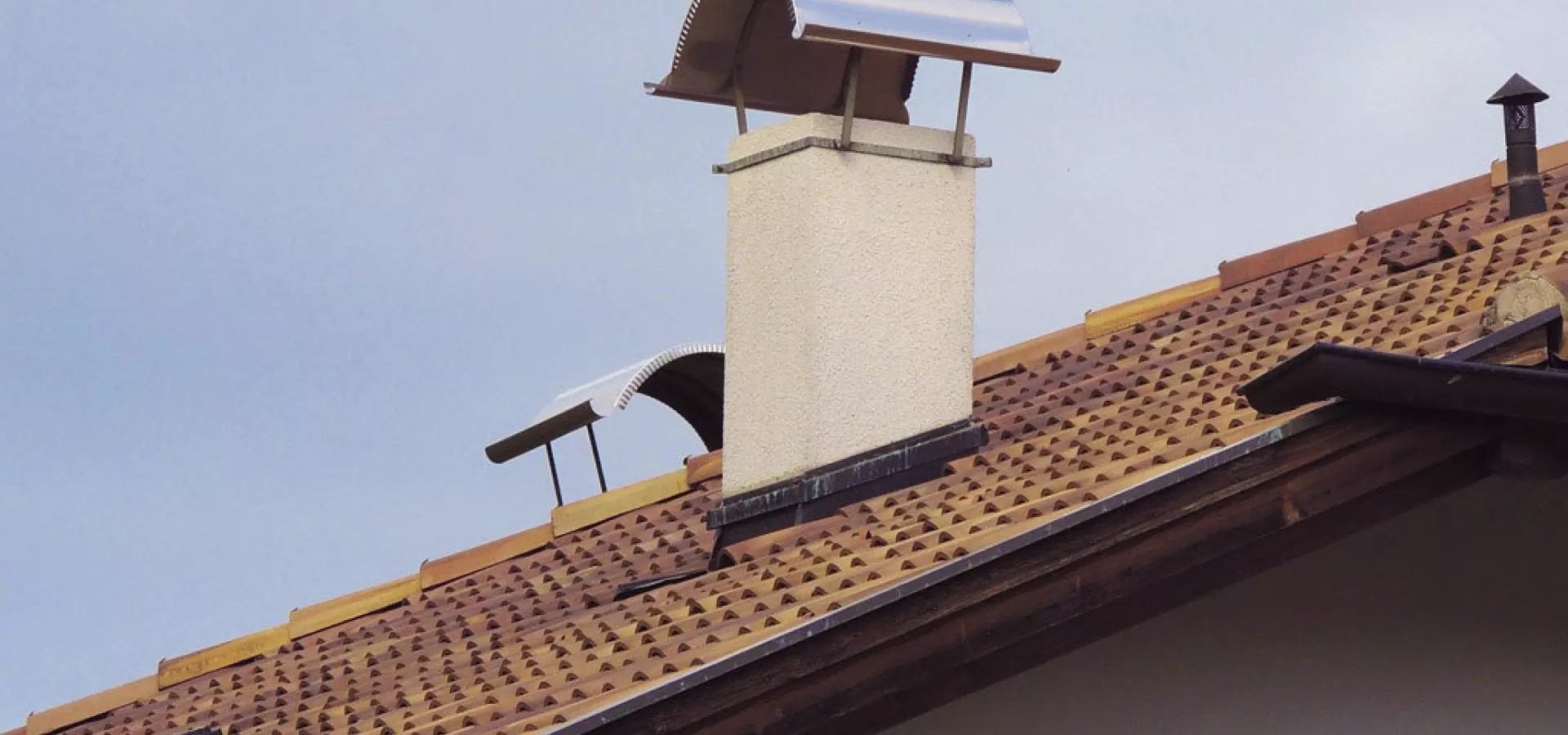 Schornstein mit Regenhaube auf Ziegeldach Schornstein mit Edelstahl-Regenhaube auf geneigtem Ziegeldach – Schutz vor Wind und Regen