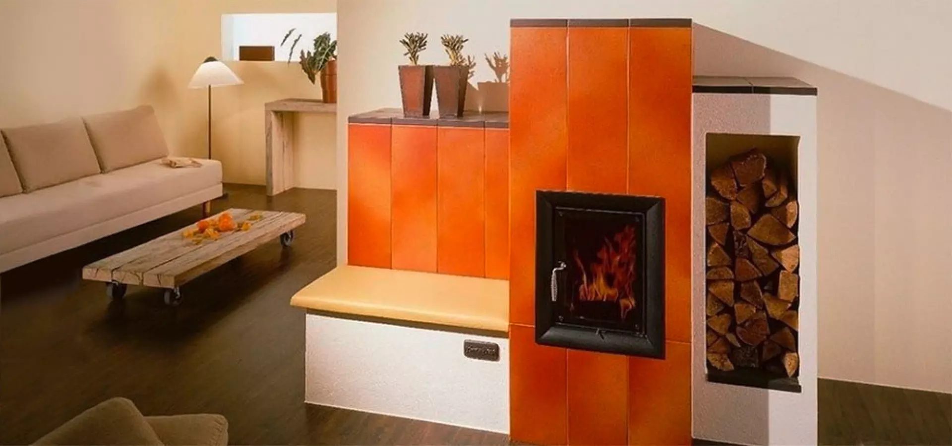 Kachelofen, Speicherofen, Keramikfront orange, Sitzbank, Holzlager, modernes Wohnzimmer, warmes Ambiente Modernes Wohnzimmer mit orange gekacheltem Kachelofen und Sitzbank; schwarze Feuerraumtür, daneben Holzlager-Nische, links Sofa und niedriger Couchtisch